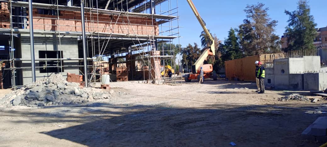 Bâtiment en construction avec échafaudages et nacelle